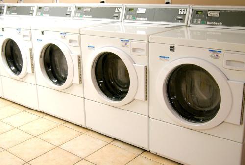 a row of white washing machines in a laundrette at Hotel Laurier - Apartment Style Residence in Waterloo