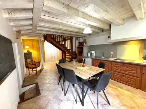 une cuisine avec une table et des chaises dans une pièce dans l'établissement Le Secret de St Cyprien, à Saint-Cyprien