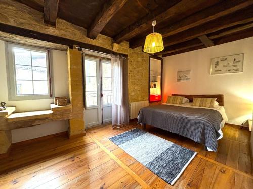 a bedroom with a bed in a room with wooden floors at Le Secret de St Cyprien in Saint-Cyprien