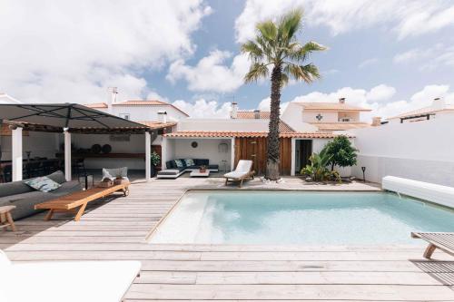 a backyard with a swimming pool and a house at Villa in Comporta Village with heated pool in Comporta