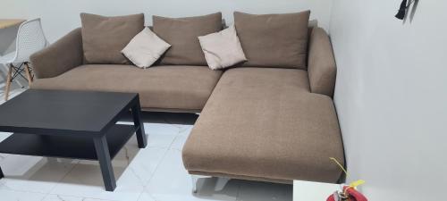 a brown couch in a living room with a table at ayser 2 in Qabāʼ