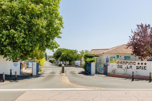 une rue vide avec une clôture et un bâtiment dans l'établissement Camping Bel Air Village La Baie, à LʼAiguillon-sur-Mer