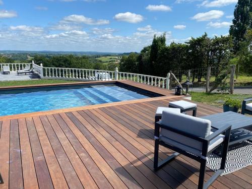 a wooden deck with a pool and a bench on a patio at Maison Pays Basque in Briscous