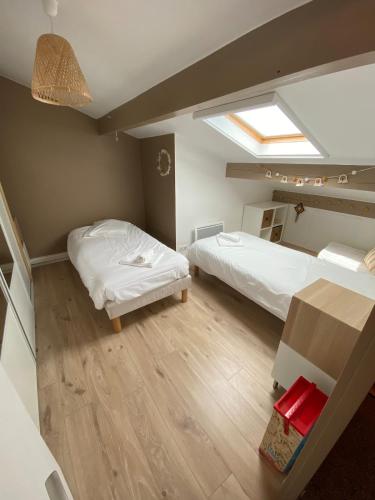 une chambre avec deux lits et une table dans l'établissement Maison Pays Basque, à Briscous