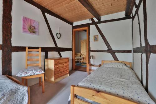 een slaapkamer met 2 bedden en een stoel in een kamer bij Hof Wiesentau in Bösdorf