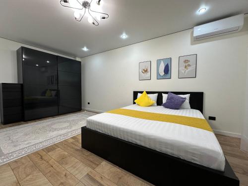 una camera da letto con un grande letto con cuscini gialli e viola di Двухкомнатной квартиры с раздельными спальнями центре Атырау ЖК Ayagoz a Atyraū