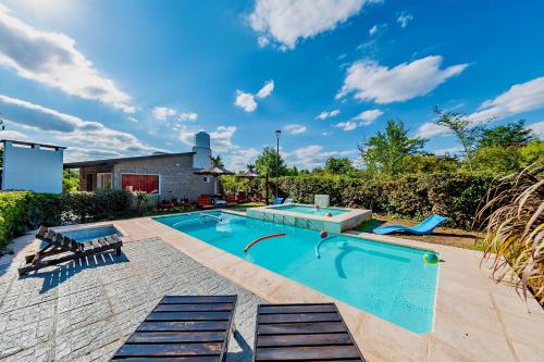 einen Pool im Garten mit zwei Liegen in der Unterkunft La Querencia in Villa Carlos Paz