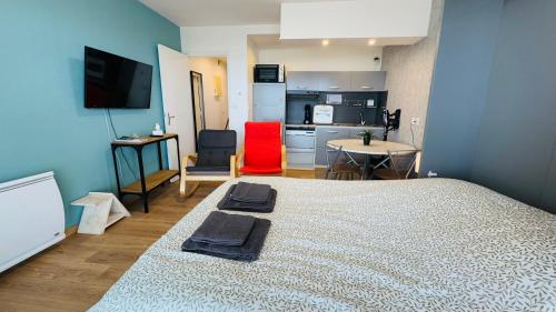 une chambre avec un grand lit et une cuisine dans l'établissement L'horizon bleu - Vue mer - Berck-sur-mer, à Berck-sur-Mer