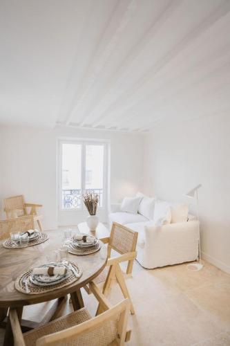 un salon avec une table et un canapé dans l'établissement Le cocon parisien by ecoflats, à Paris