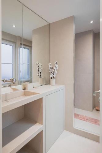 une salle de bain avec deux lavabos et un miroir dans l'établissement Le cocon parisien by ecoflats, à Paris