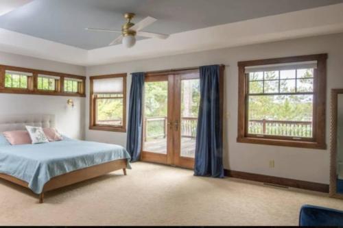 a bedroom with a bed and some windows at Stony Crest Cabin Deer Lake in Three Lakes
