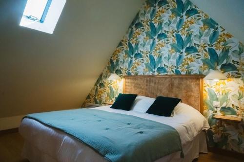 a bedroom with a bed with a floral wallpaper at Gîte Sidonie in Apremont