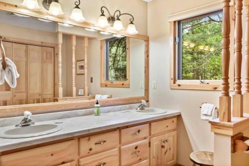 a bathroom with two sinks and a large mirror at Big St Lodge on Big St Germain Lake in Saint Germain