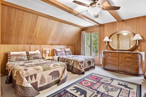 a bedroom with two beds and a mirror and a dresser at Big St Lodge on Big St Germain Lake in Saint Germain