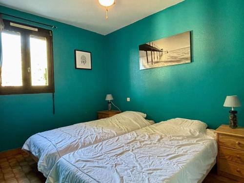 une chambre avec un lit avec un mur bleu dans l'établissement Appartement 3 pièces, 4 couchages, climatisé, piscine, parking, proche plage - Argelès-sur-Mer - FR-1-225-349, à Argelès-sur-Mer