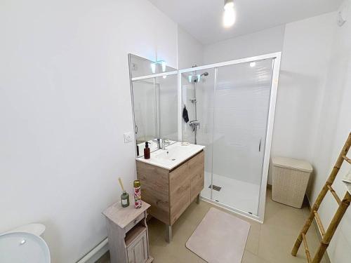 une salle de bain blanche avec une douche et un lavabo dans l'établissement Charmant appartement proche plage avec balcon et parking privé - FR-1-465-123, à Cabourg