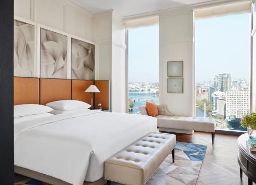 a bedroom with a large white bed and a large window at Park Hyatt London River Thames in London