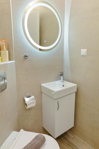 a bathroom with a white sink and a mirror at Cem's Cozy Apartment in Xanthi