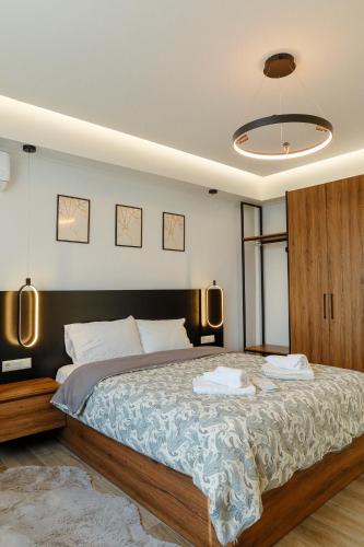 a bedroom with a large bed with two towels on it at Cem's Cozy Apartment in Xanthi