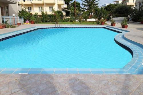 a large swimming pool with blue tile in a yard at Litinas Apartments with pool in Agia Marina Nea Kydonias