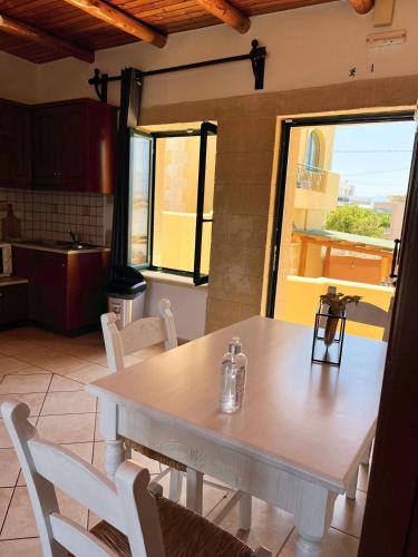 a white table and chairs in a kitchen at Skandalis Apartments with pool in Chorafakia