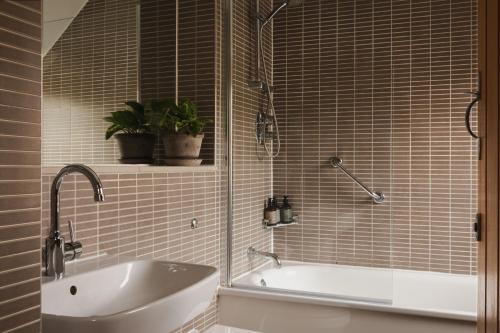 a bathroom with a tub and a sink and a mirror at The Pilsley Inn - Chatsworth in Baslow