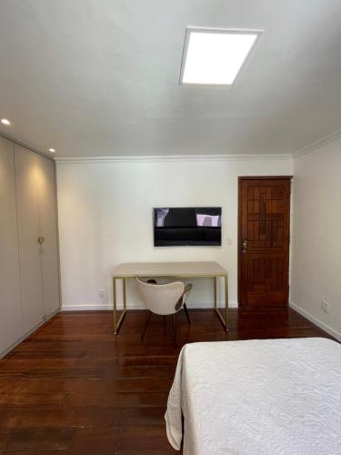 a bedroom with a bed and a desk and a window at Suíte na casa amazônica in Manaus