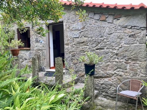 a stone house with a chair in front of it at Maison traditionnelle Areosa in Viana do Castelo