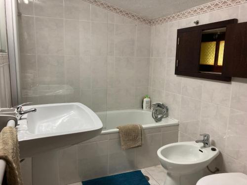 a bathroom with a tub and a toilet and a sink at Maison traditionnelle Areosa in Viana do Castelo