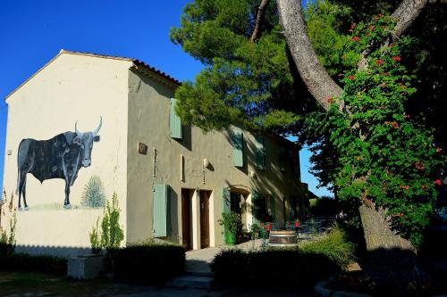 un edificio con una vaca pintada a un lado. en MANADE SAINT LOUIS Mas de La Paix en Montcalm