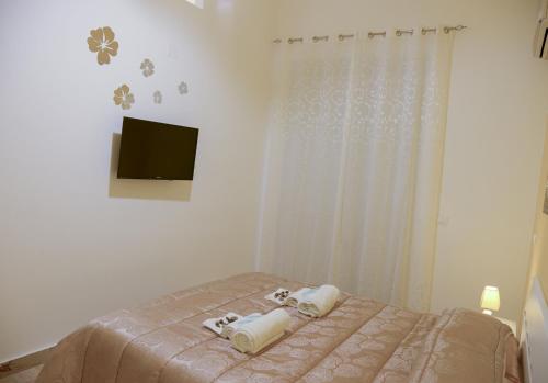 a bedroom with a bed with two towels on it at Case Saniela in Terrasini
