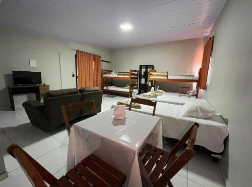 een woonkamer met een bed, een tafel en stoelen bij Sol lar hotel flats in Paragominas