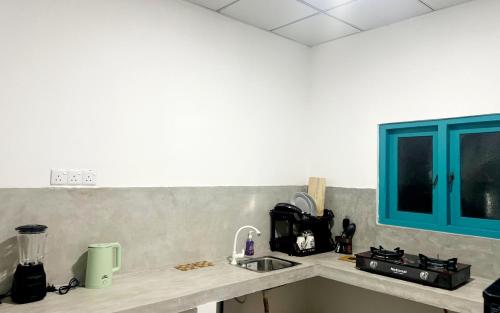 a kitchen counter with a sink and a blue window at CozyBlu Villa Ahangama in Ahangama