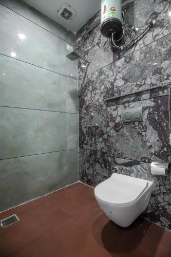 a bathroom with a toilet and a stone wall at Hotel Magnum 2 in Kharar