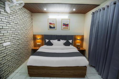 a bedroom with a large bed with blue curtains at Hotel Magnum 2 in Kharar