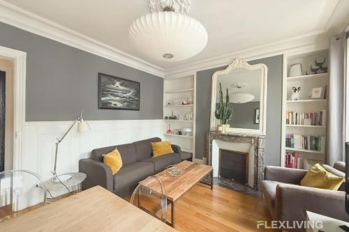 un salon avec un canapé et une cheminée dans l'établissement Flexliving - Whole flat - Crozatier, à Paris