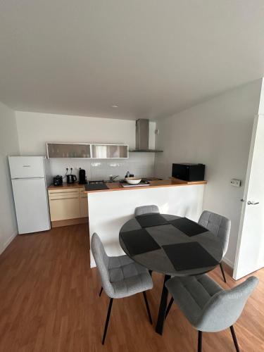 une cuisine avec une table et des chaises dans une cuisine dans l'établissement Appartement chaleureux proche du centre et de la plage, à Crozon