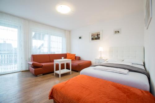 a bedroom with a bed and a couch at Apartments Grom in Bled