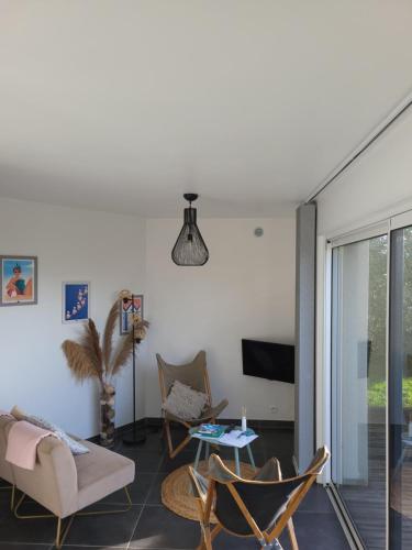 a living room with a couch and chairs and a tv at Baie du Mont-Saint-Michel et Côte Normande - Les Secrets du Rivage in Saint-Pair-sur-Mer
