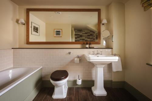 a bathroom with a sink and a toilet and a tub at The Pilsley Inn - Chatsworth in Baslow