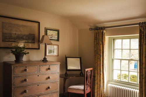a bedroom with a dresser and a window and a chair at The Pilsley Inn - Chatsworth in Baslow