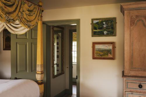 a bedroom with a bed and a door and some pictures at The Pilsley Inn - Chatsworth in Baslow