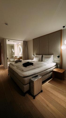 a bedroom with a large bed and a suitcase at Haven Mountain Retreat in Sankt Johann im Pongau
