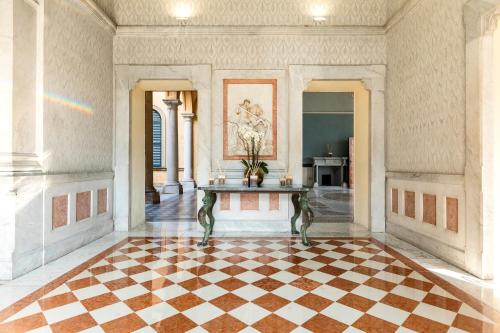 a room with a table and a checkerboard floor at Hotel Villa Cipressi, by R Collection Hotels in Varenna