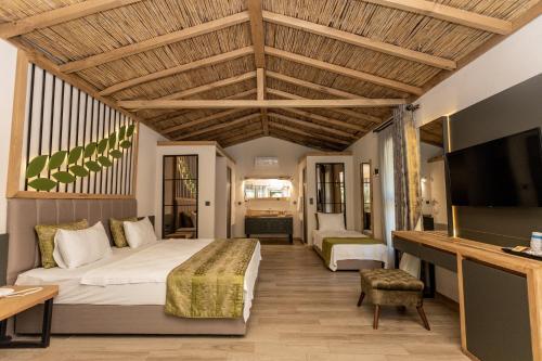 a hotel room with a bed and a tv at Gizli Cennet Villages Hotel in Fethiye