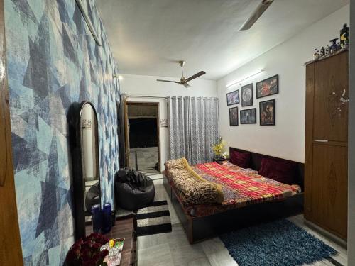 a bedroom with a bed and a couch in a room at Double room with balcony in Prayagraj