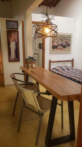 a wooden table and chairs in a room with a bed at Hotel Campestre Villa Nico in Bochalema