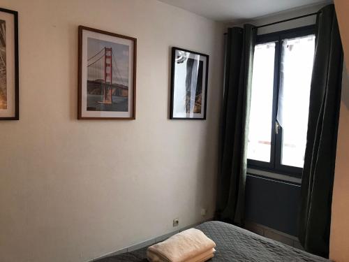 - une chambre avec 2 photos sur le mur et un lit dans l'établissement City and Nature, à Aleçon