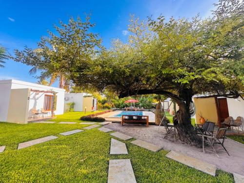 a garden with a table and a tree at Telvina Beach Lodge in Vilanculos