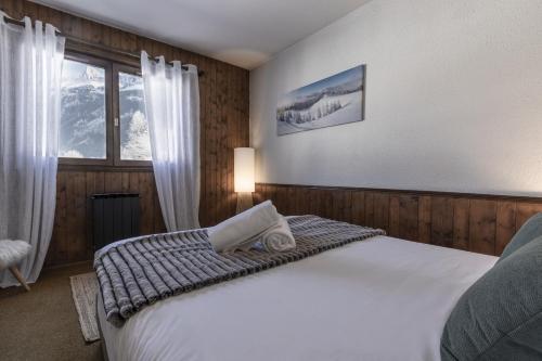 une chambre avec un lit et une fenêtre dans l'établissement Le Miage, à Chamonix-Mont-Blanc